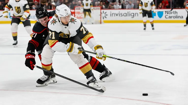William Karlsson #71 of the Golden Knights skates with the puck against Alexander Nikishin #21 of the Hurricanes