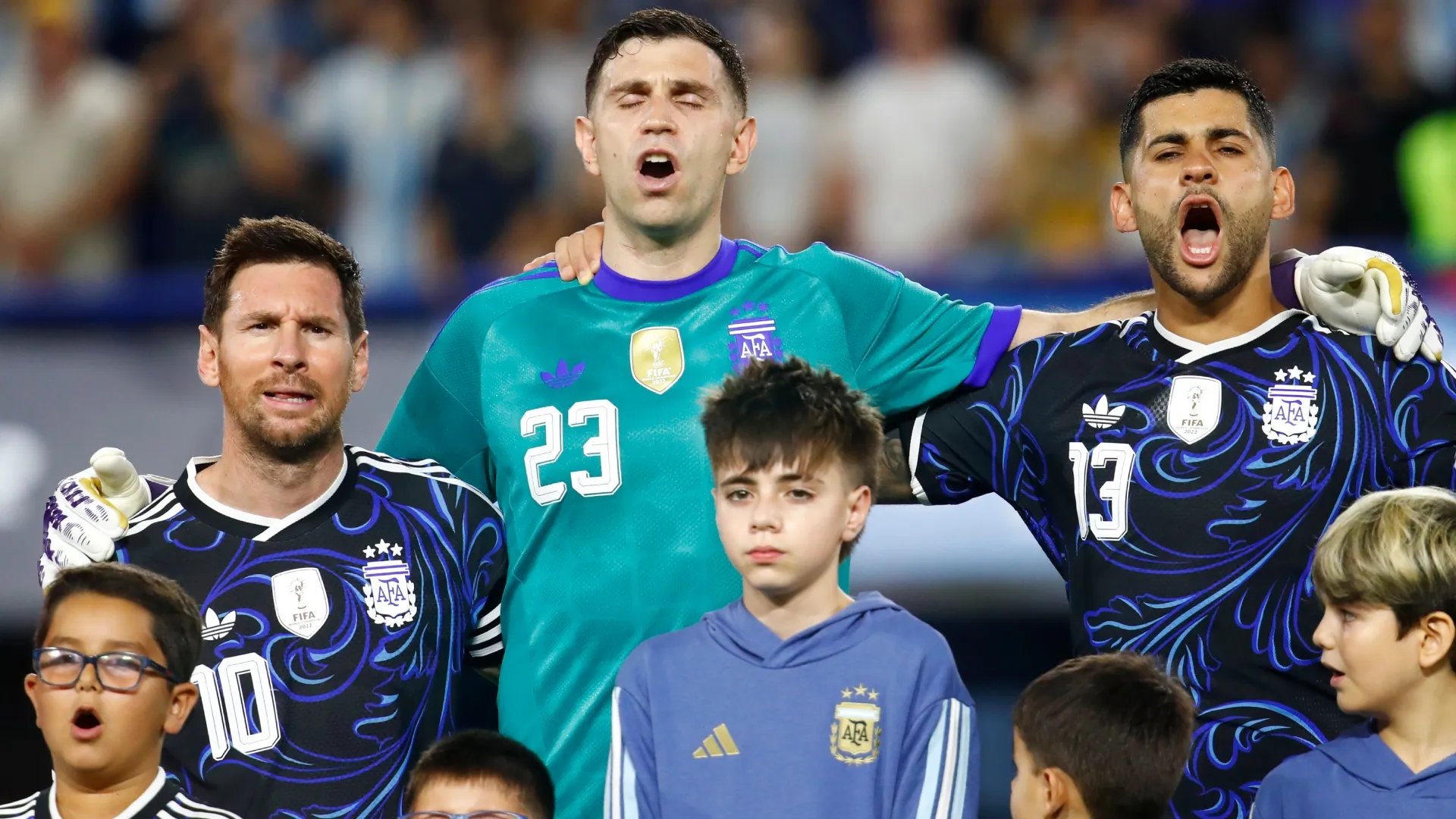 Lionel Messi, Emiliano Martinez and Cristian Romero of Argentina sing the national anthem. Marcos Brindicci/Getty Images