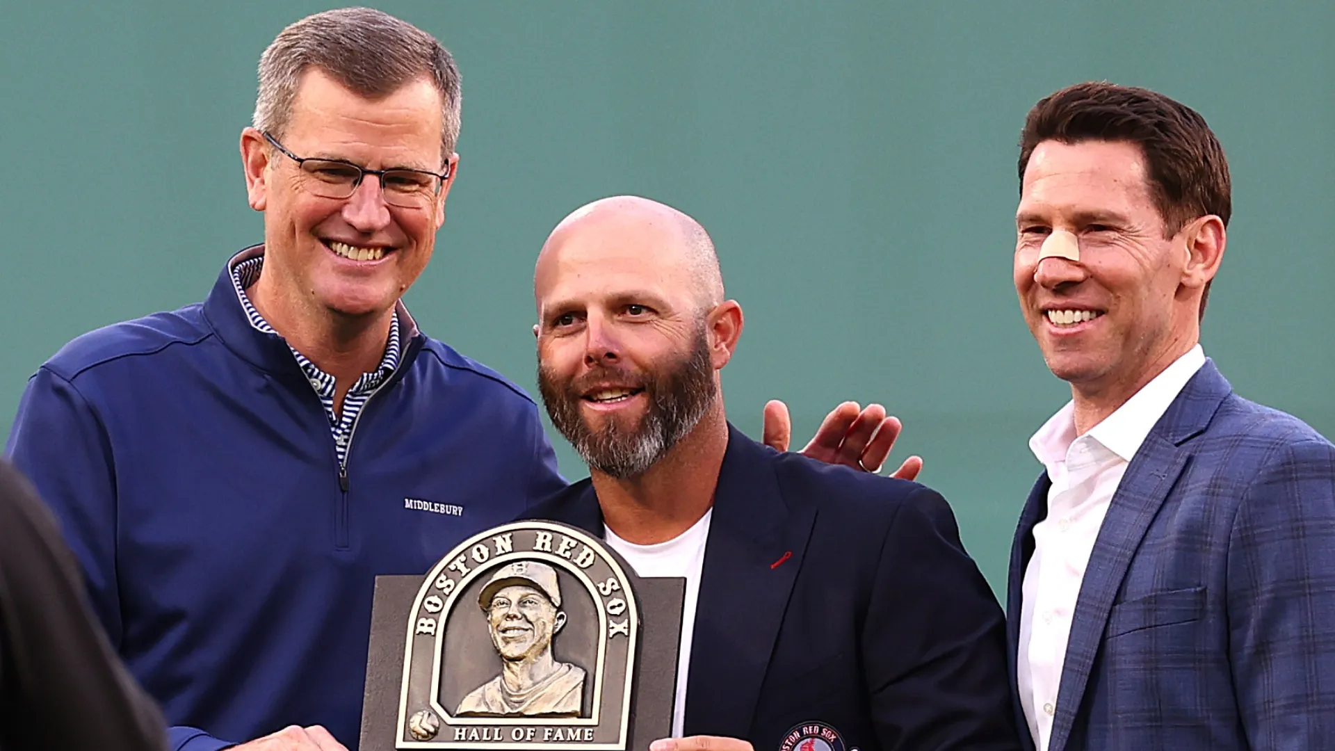 Sam Kennedy, left, and Chief Baseball Officer Craig Breslow pose former Red Sox player Dustin Pedroia. Maddie Meyer/Getty Images