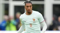 Michael Olise of France runs with the ball.