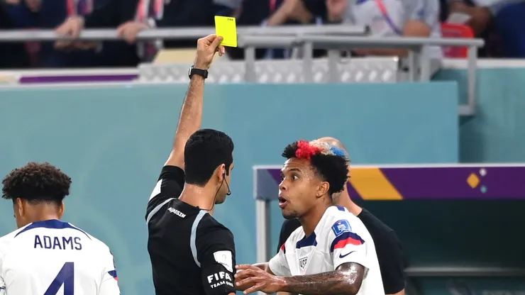 Weston McKennie of United States is shown a yellow card during the 2022 World Cup.