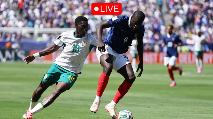 Dayot Upamecano #4 of France controls the ball under pressure from Ismaila Sarr #18 of Senegal.