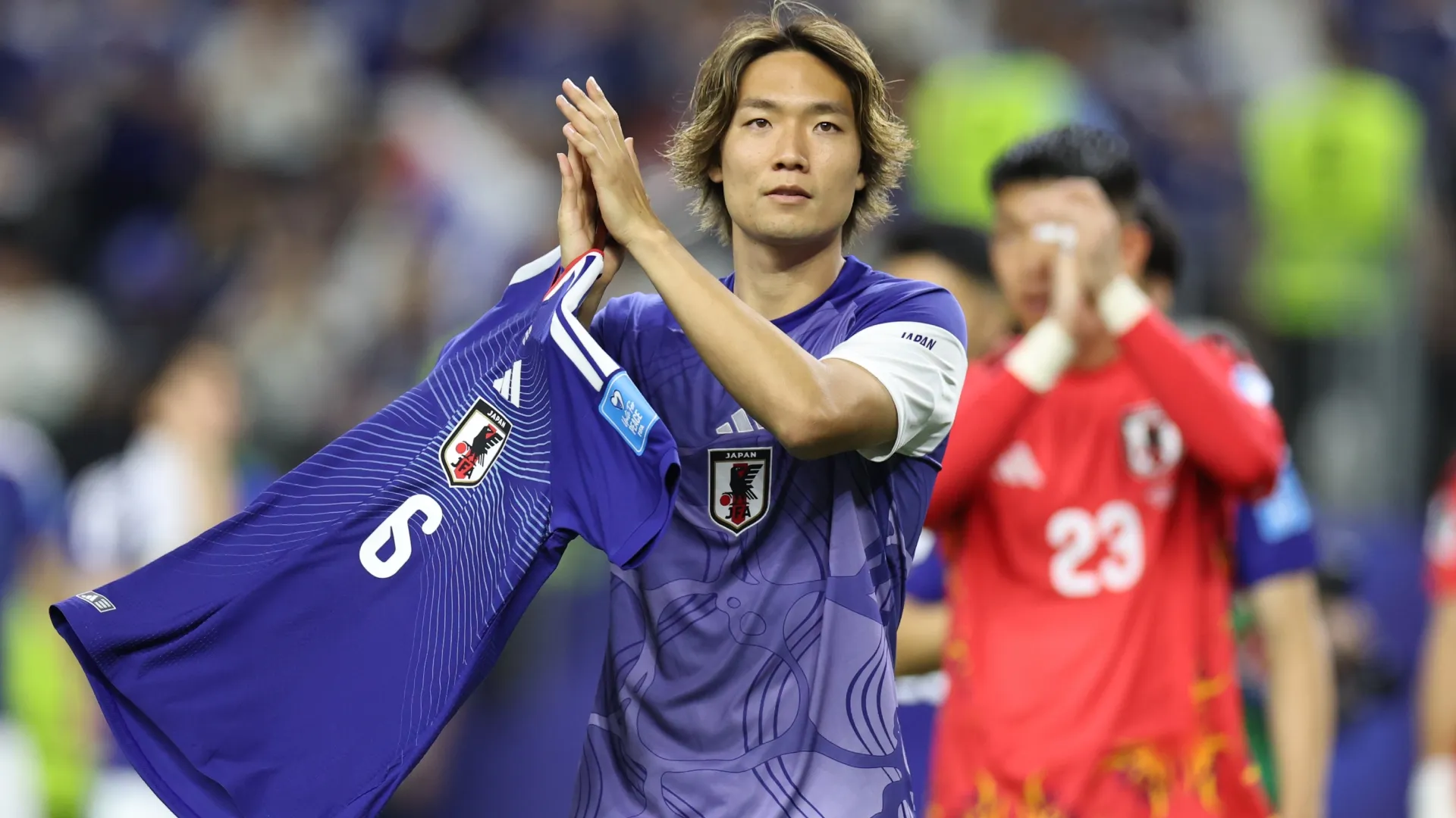 Kou Itakura #4 of Japan holding the shirt of Wataru Endo applauds fans after the 1-1 draw.  Stacy Revere/Getty Images