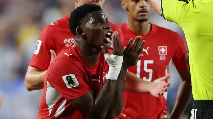 Breel Embolo #7 of Switzerland argues with referee Joao Pinheiro following his second yellow card.