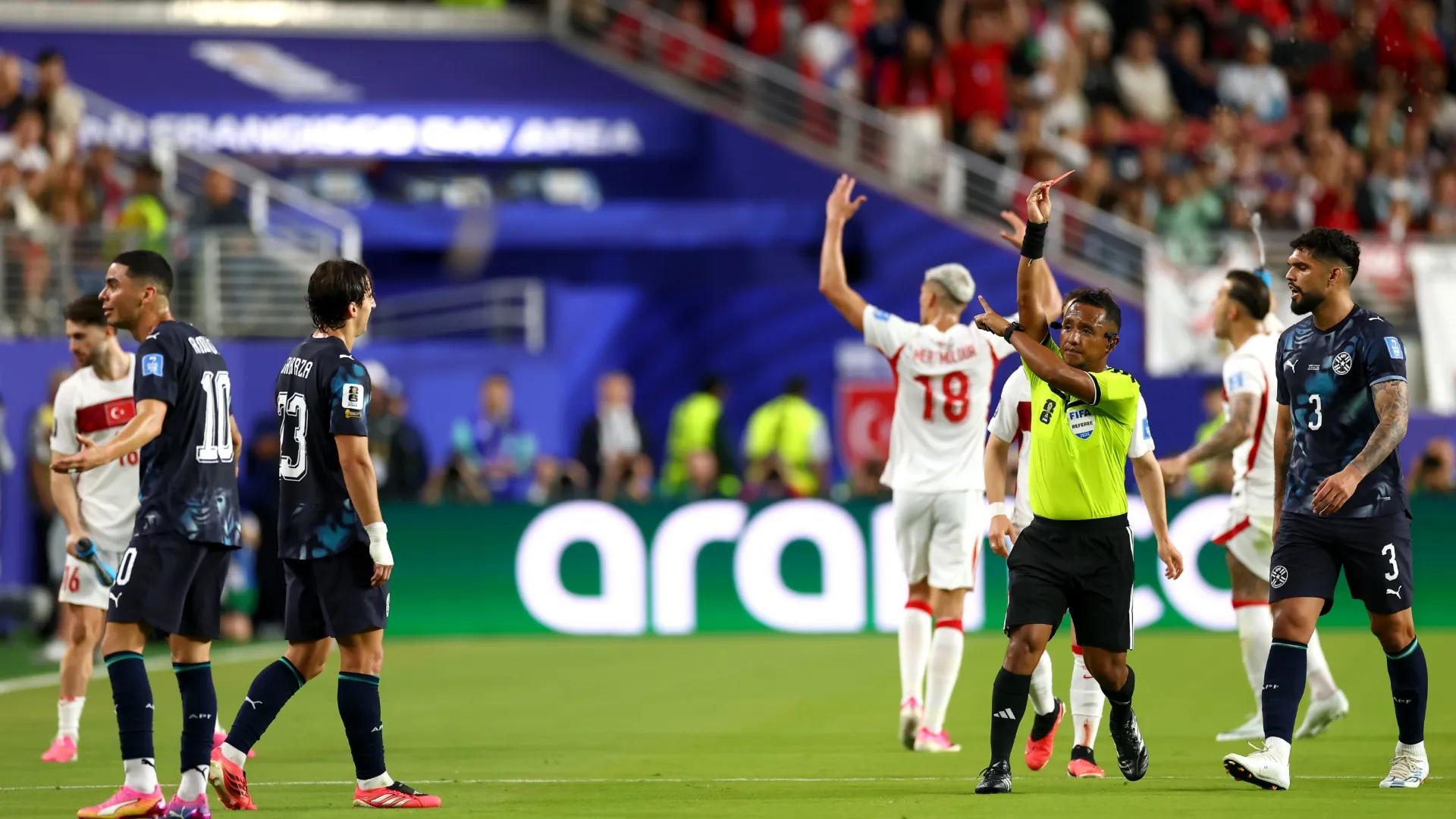Referee Ivan Barton issues a red card to Miguel Almiron #10 of Paraguay