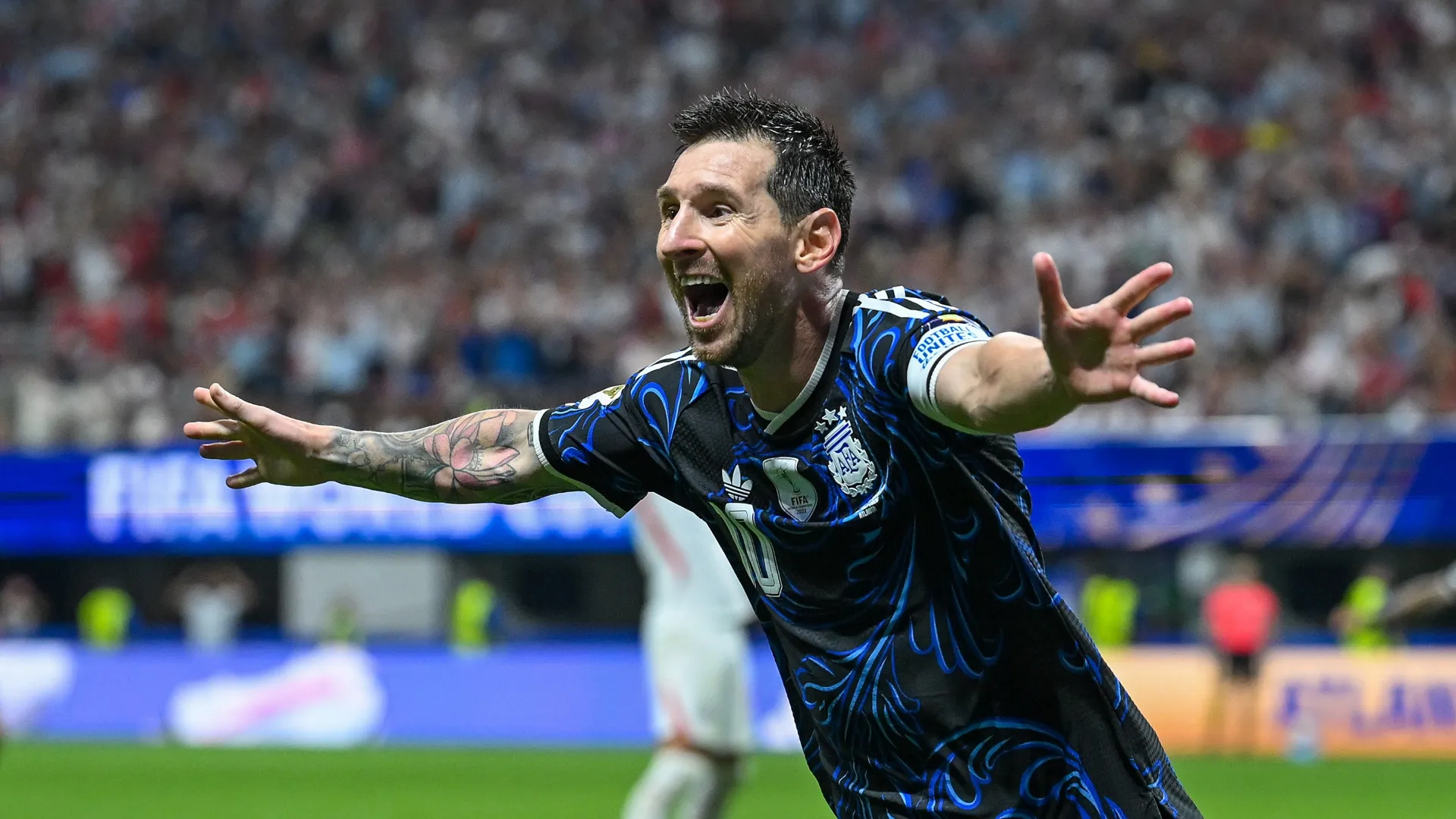 Lionel Messi opens his arms to celebrate a goal.