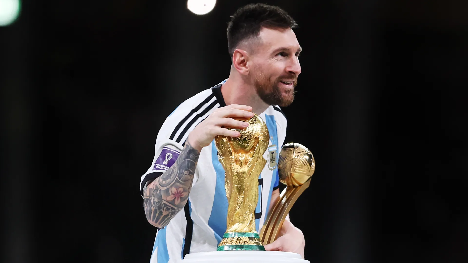 Messi with the Golden Ball and World Cup in 2022