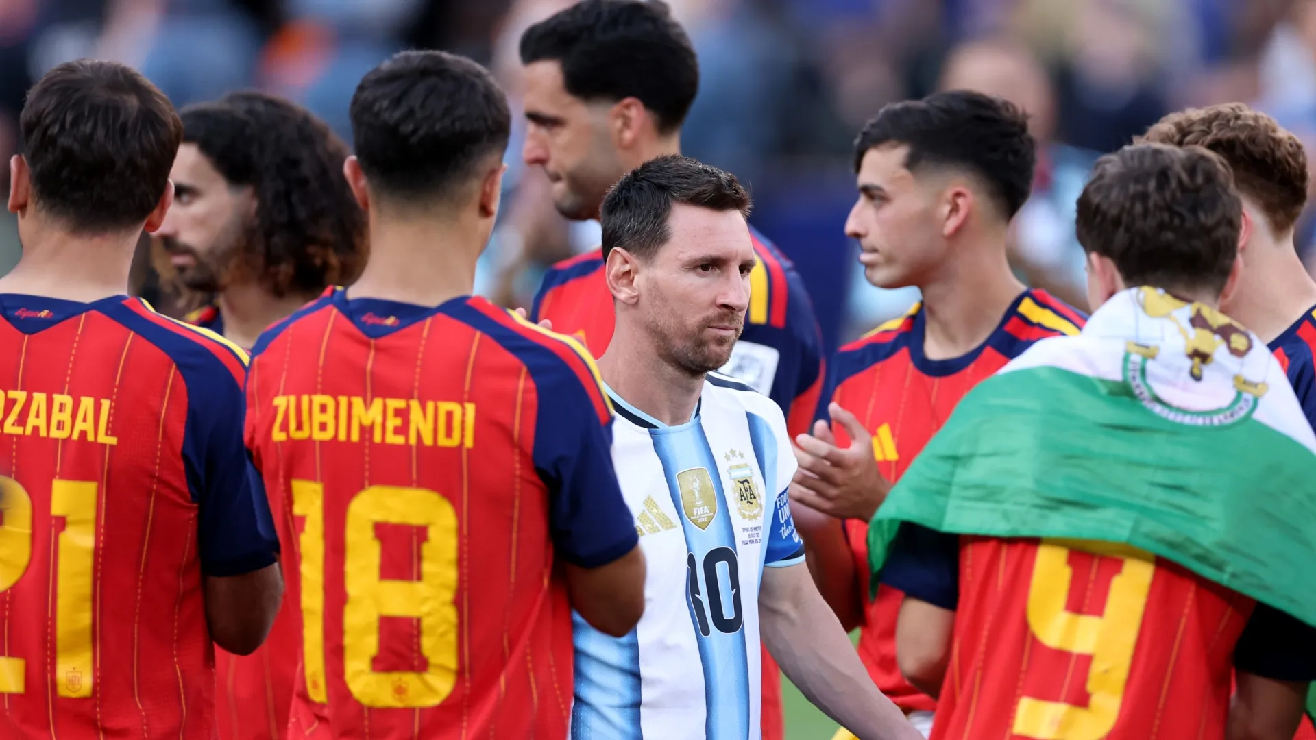 Lionel Messi #10 of Argentina walks to the podium while embraced by players of Spain. Justin Setterfield/Getty Images