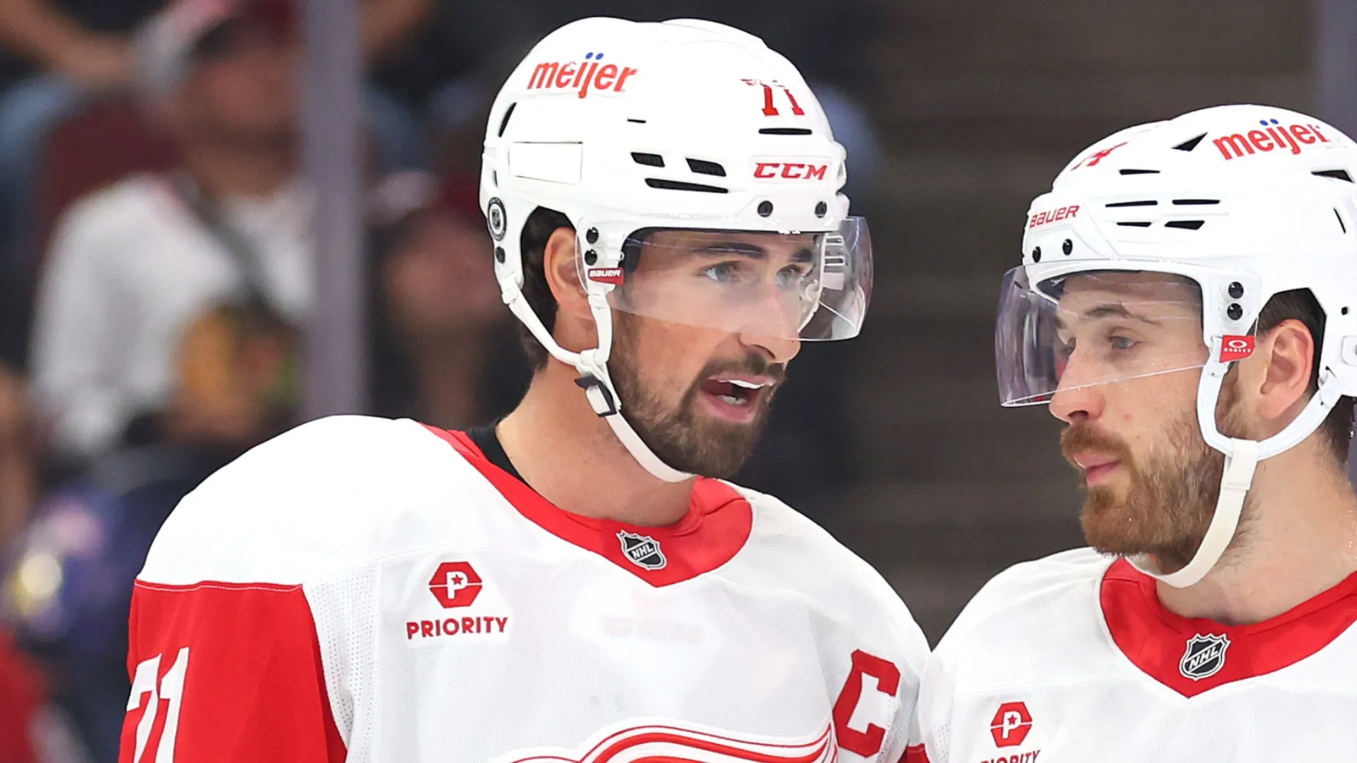 Dylan Larkin #71 of the Detroit Red Wings confer against the Chicago Blackhawks during the first period of a preseason game at the United Center on September 25, 2024 in Chicago, Illinois.