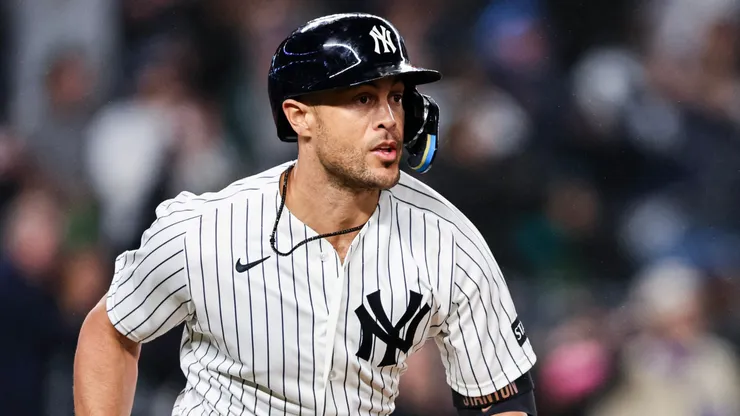 Giancarlo Stanton #27 of the New York Yankees runs to first after hitting an RBI double.