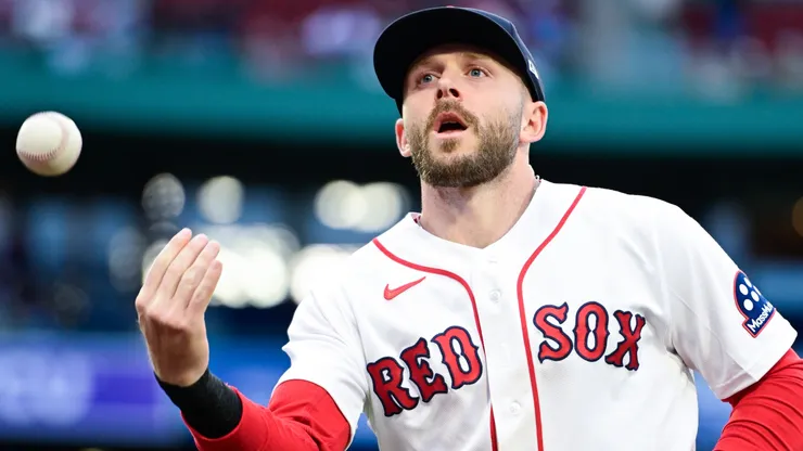 Trevor Story #10 of the Boston Red Sox tosses a ball to a fan between innings.
