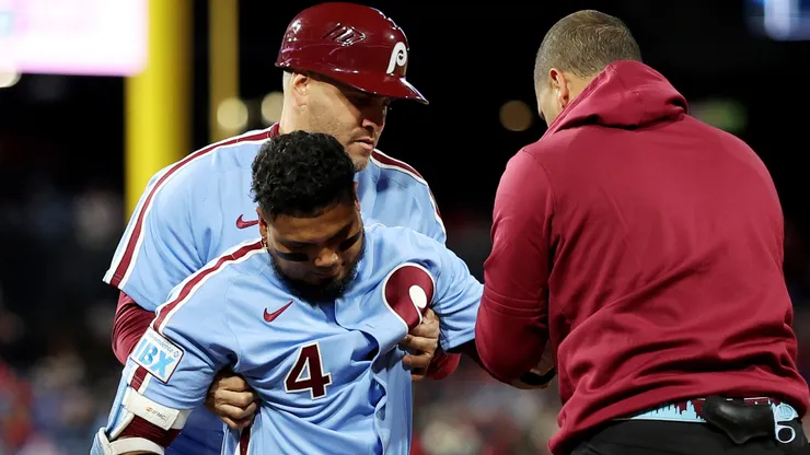 Staff help up Luis Arraez #4 of the Philadelphia Phillies after an injury.