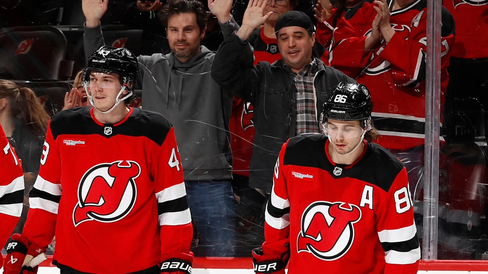 Luke (left) and Jack Hughes (right) playing for the Devils.