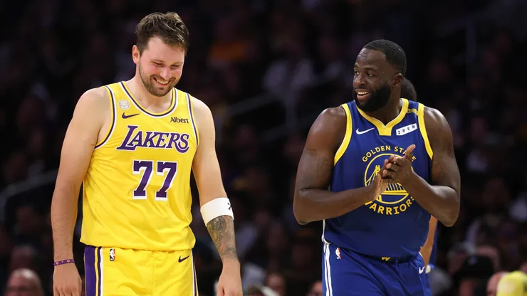 Luka Doncic #77 of the Los Angeles Lakers shares a laugh with Draymond Green #23 of the Golden State Warriors.