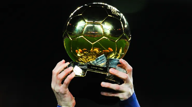 Lionel Messi of FC Barcelona holds up the FIFA Ballon d'Or trophy