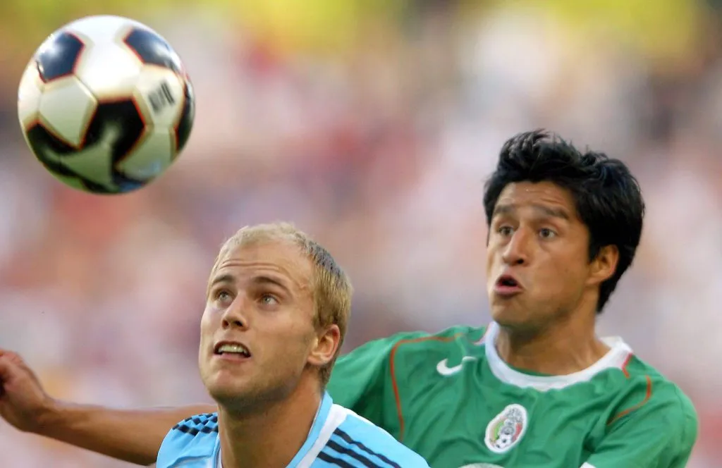 Osorio disputa un balón contra otro ex cementero, Luciano Figueroa (Imago).