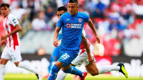 Roberto Alvarado en disputa del balón ante Necaxa.