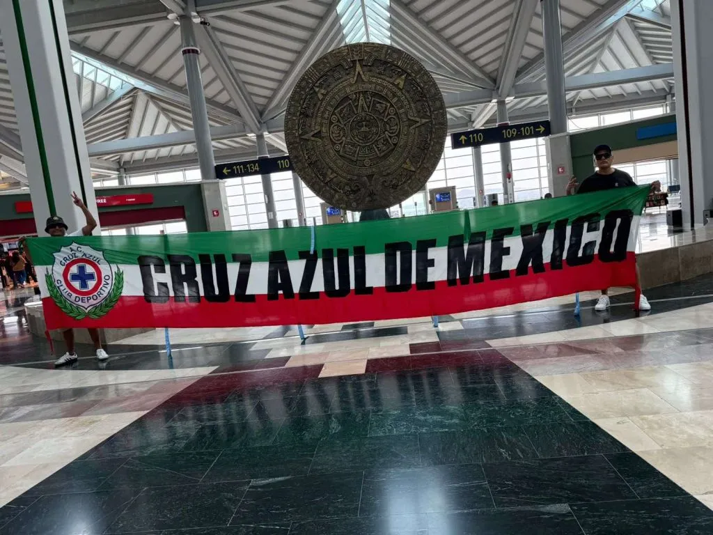 Hugo Enrique García (izquierda) y el lienzo que lo acompañó al Mundial de Qatar.