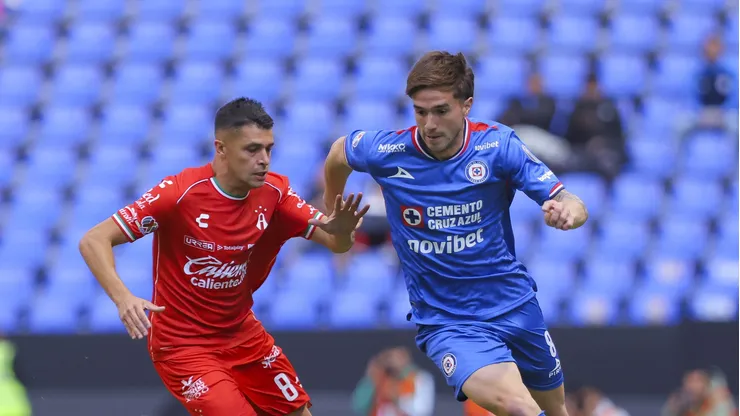 PUEBLA, MEXICO - JANUARY 14: Agustin Palavecino of Cruz Azul competes for the ball with Mateo Garcia of Atlas during the 2nd round match between Cruz Azul and Atlas as part of the Torneo Clausura 2026 Liga MX at Cuauhtemoc Stadium on January 14, 2026 in Puebla, Mexico. (Photo by Agustin Cuevas/Getty Images)