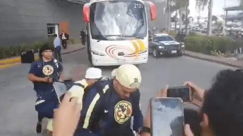 Aficionados reciben al plantel de América en su hotel.