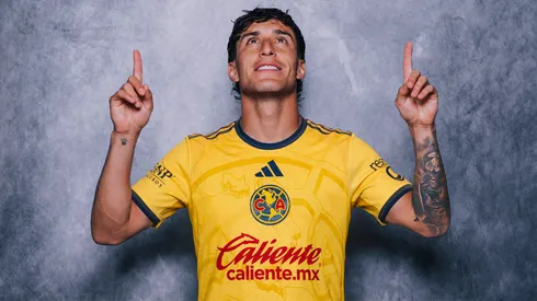 @Crea una imagen A la persona de la primera imagen, ponle la camiseta de la segunda imagen, que la textura de la ropa sea muy realista, que las físicas de la playera también sean realistas, ya que esta persona se está jalando la playera y debe adaptarse bien la playera a las físicas de su mano, y que esté bien amoldada a su cuerpo. La imagen debe ser horizontal.