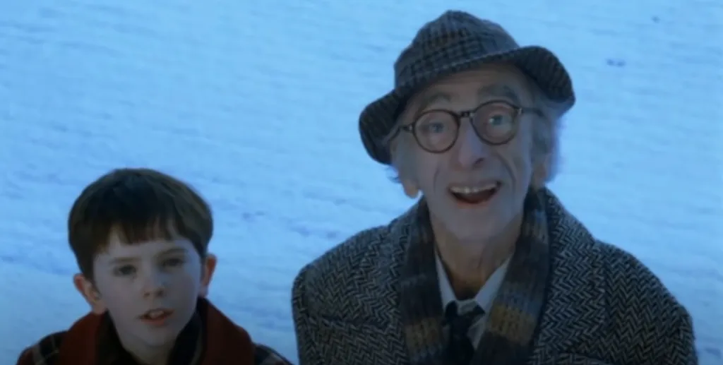 Freddie Highmore (Charlie Bucket) junto con David Kelly (Joe Bucket) en una escena de la película. Imagen: @dobladictos.