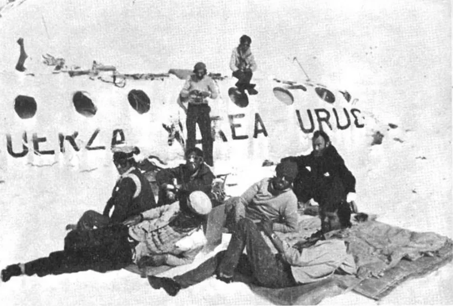 Esta es otra imagen que quedó para la historia, en la que los sobrevivientes de los Andes descansan afuera de los restos del avión. Imagen: Sociedad de la Nieve.