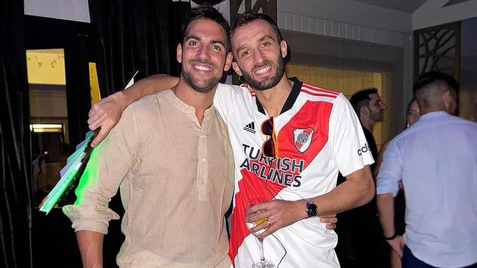 Pezzella posando con la camiseta de River a la distancia.