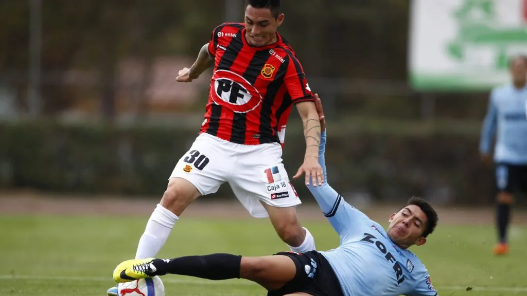 Benavídez, en el piso peleando por la pelota en un partido con Iquique (IMAGO / Photosport).