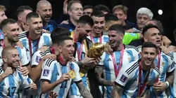 Messi con la Copa del Mundo ante la mirada de sus compañeros.