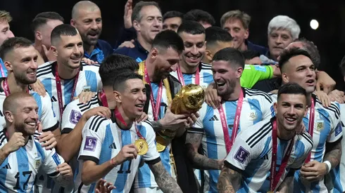 Messi con la Copa del Mundo ante la mirada de sus compañeros.