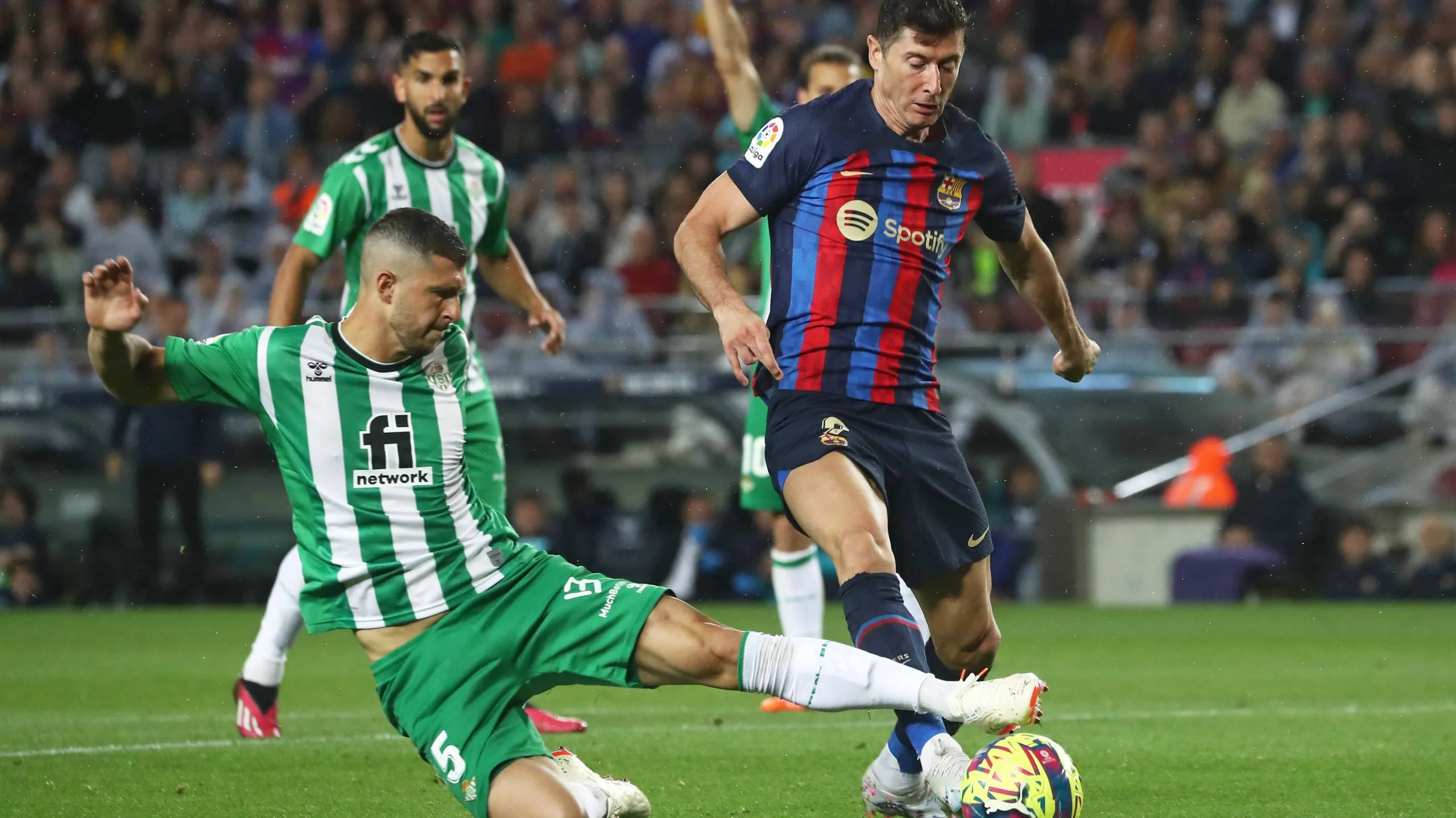 Guido Rodríguez en la disputa de la pelota con Robert Lewandowski, quien podría ser su compañero a partir de la temporada 2024/2025.