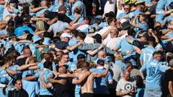 Los hinchas de Manchester City festejan de espaldas.