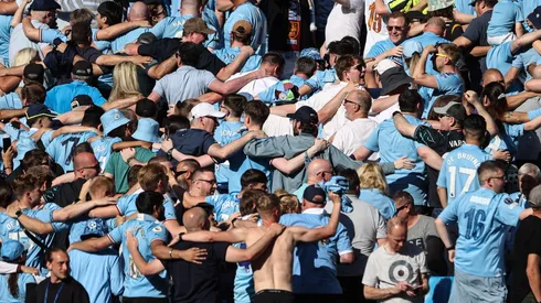 Los hinchas de Manchester City festejan de espaldas.