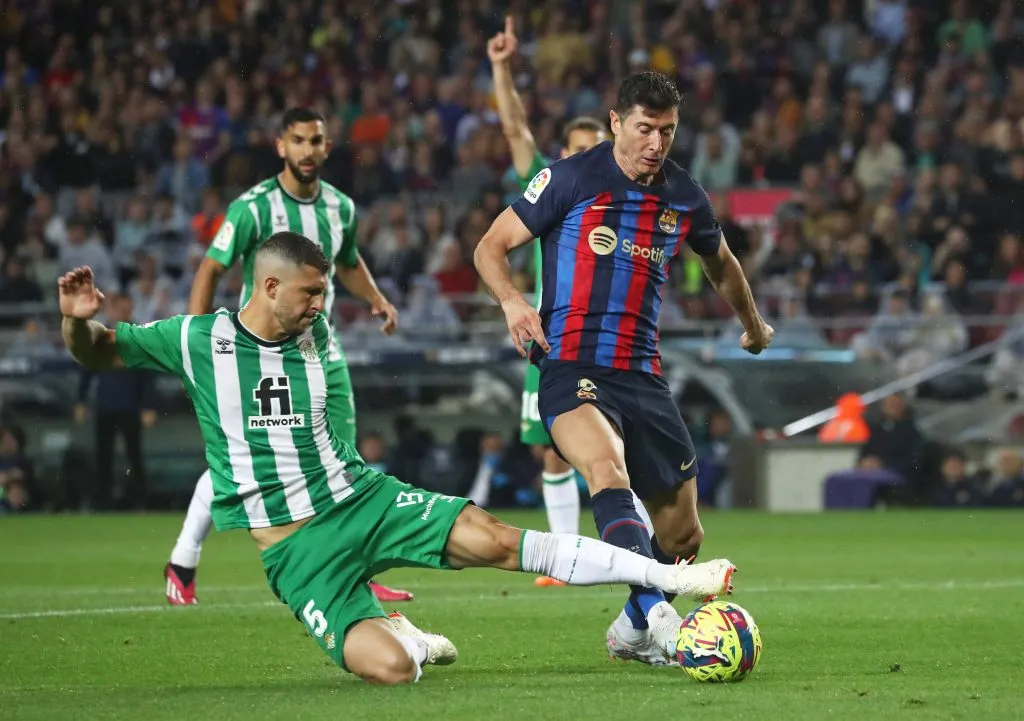 Guido Rodríguez disputando la pelota con Robert Lewandowski, quien podría ser su compañero a partir de la próxima temporada.