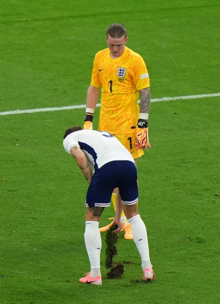 John Stones levantando un gran pedazo de césped (IMAGO / PA Images).