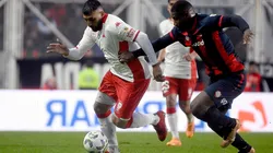 Ramón Ábila y Jhohan Romaña disputan la pelota en el empate 1-1 entre Huracán y San Lorenzo en la Liga Profesional 2024.