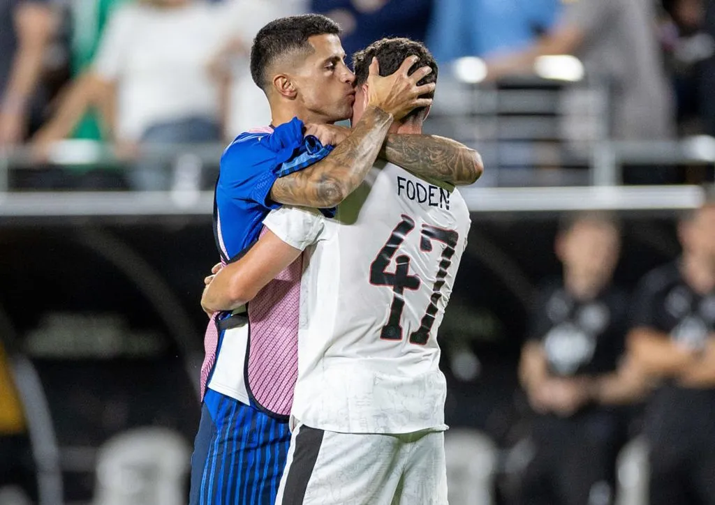 Sentido abrazo entre Cancelo y Foden tras el partido.