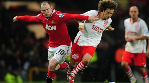 Sergio Torres disputa el balón con Wayne Rooney.