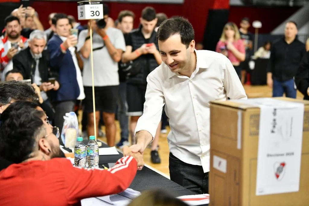 Di Carlo saluda a las autoridades de la mesa en la que votó.