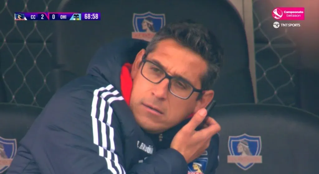 Rubén Bascuñán fue sorprendido en pleno partido con una radio hablando y escuchando cosas en la banca de Colo Colo (Pantallazo TNT Sports)