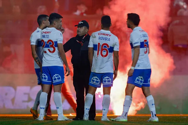 Momento en que el duelo entre la UC y Ñublense estaba detenido por el lanzamiento de bengalas a la cancha (Photosport)