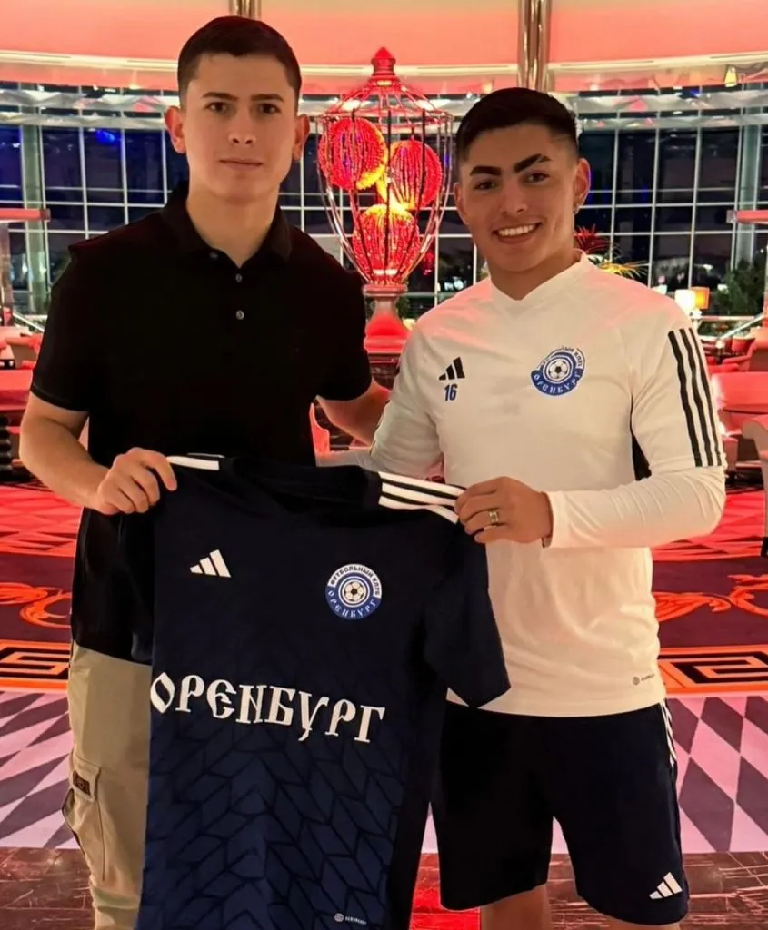 Jordhy Thompson junto a su representante Joaquín Morales mostrando la camiseta del FC Orenburg.