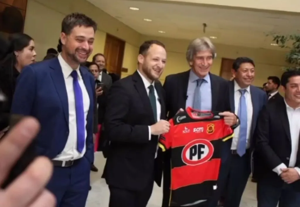 Manuel Pellgrini junto al diputado Jorge Guzmán posando con la camiseta de Rangers de Talca.