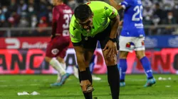 El árbitro del compromiso recogiendo una piedra que cayó a la cancha.