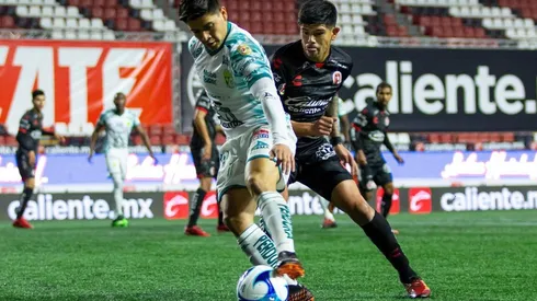 Víctor Dávila disputa el balón con Esteban Pavez en la Liga MX. (Foto: Agencia UNO)