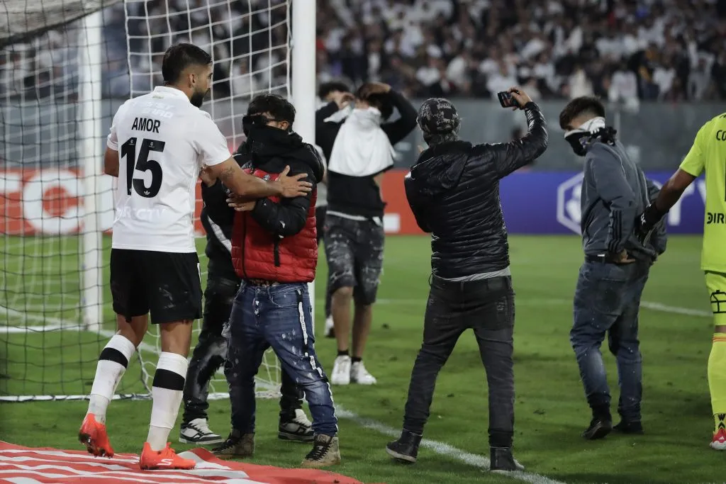 Los jugadores de Colo Colo intentaron frenar la avalancha de barristas que ingresaron a la cancha del Estadio Monumental. (Foto: Felipe Zanca/Photosport)