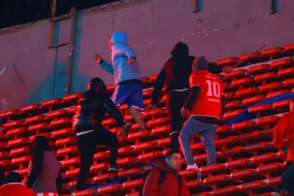 Hincha de la U arrancando de los simpatizantes del Rojo | FOTO: Fotobaires/Photosport