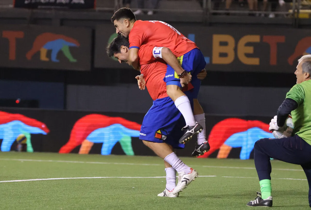 David Pizarro a la espalda de Iván Zamorano en el amistoso Rojo Histórico (Photosport).