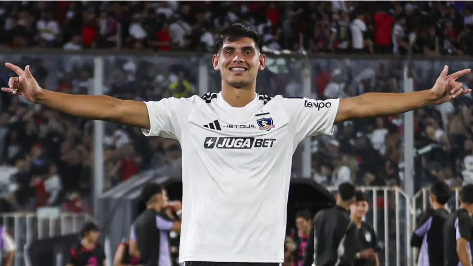 Marcelo Barticciotto pone la pelota al piso por la sorpresiva irrupción de Yastin Cuevas (Foto: Photosport)